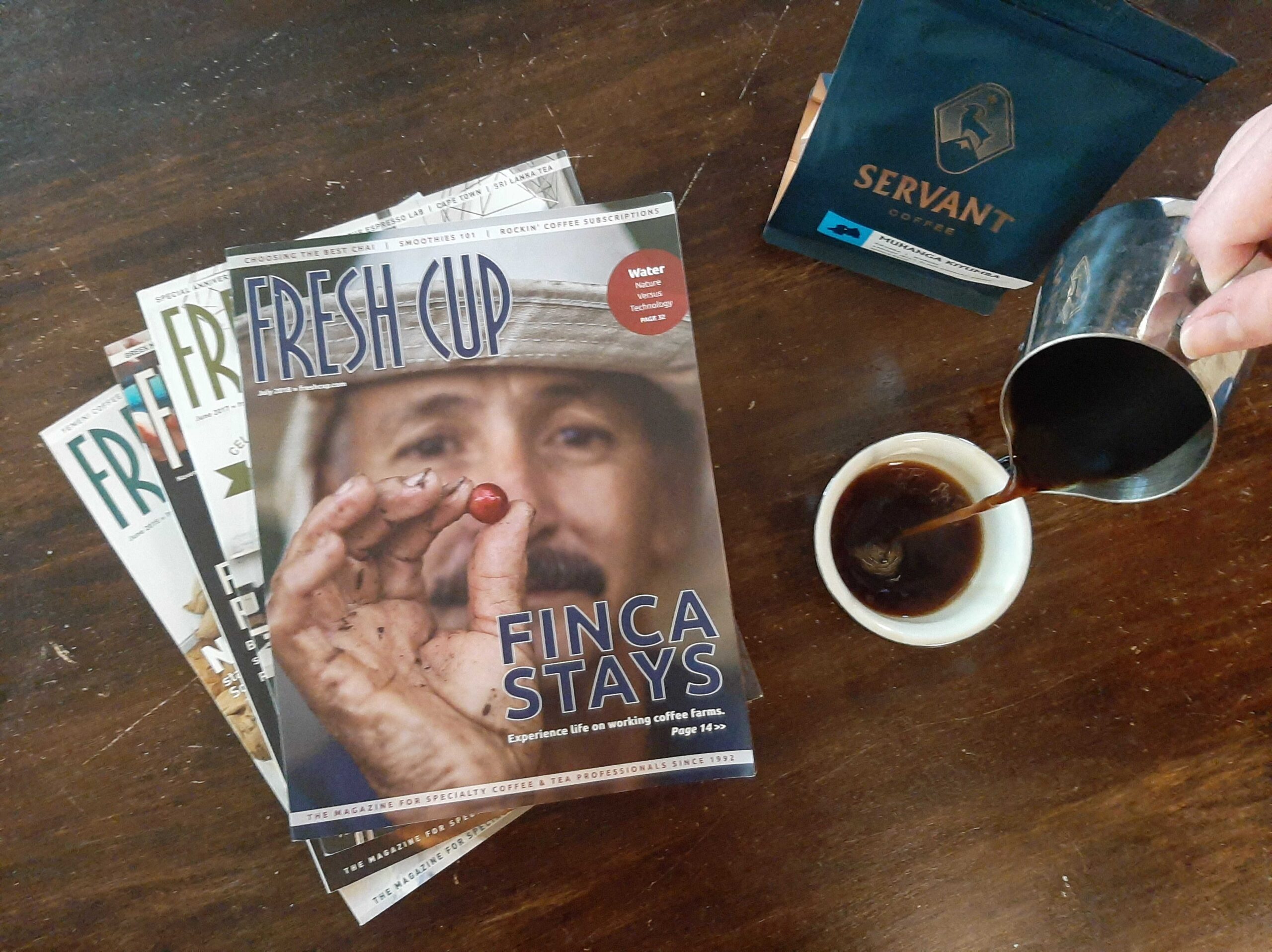 Pouring a fresh cup of coffee with old issues of Fresh Cup Magazine