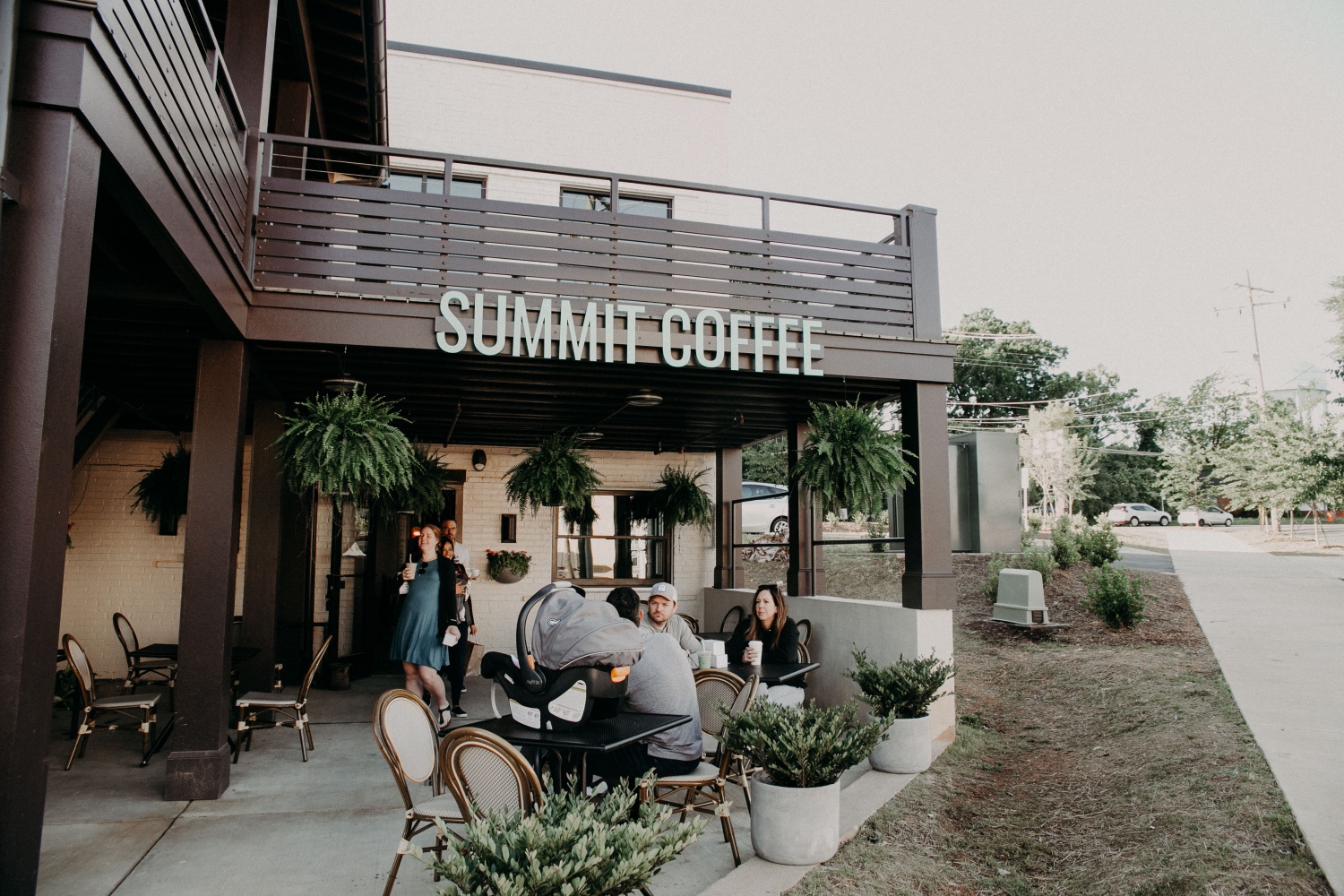 An outside photo of Summit Coffee, a coffee shop with people sitting around.